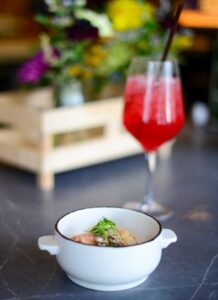a bowl of food and a glass of wine