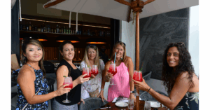 a group of women posing for the camera with a drink in their hands