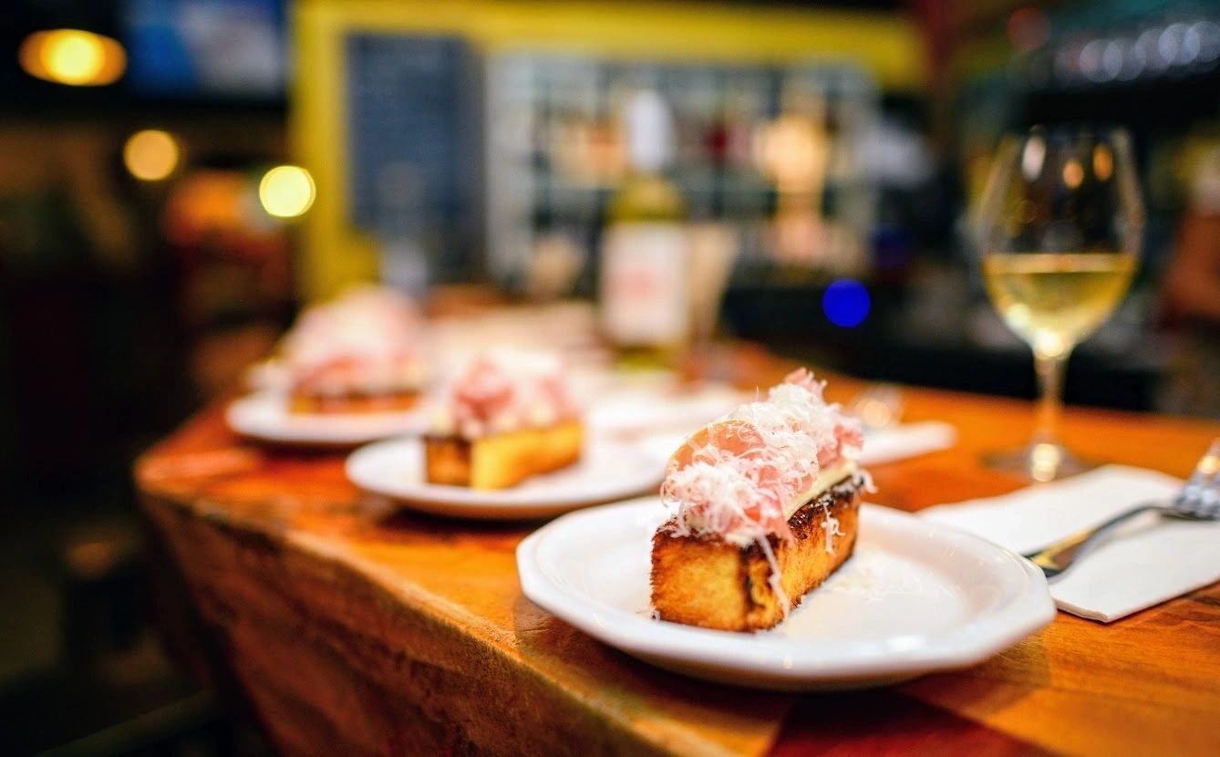 close up of a plate of food and glasses of wine on a table