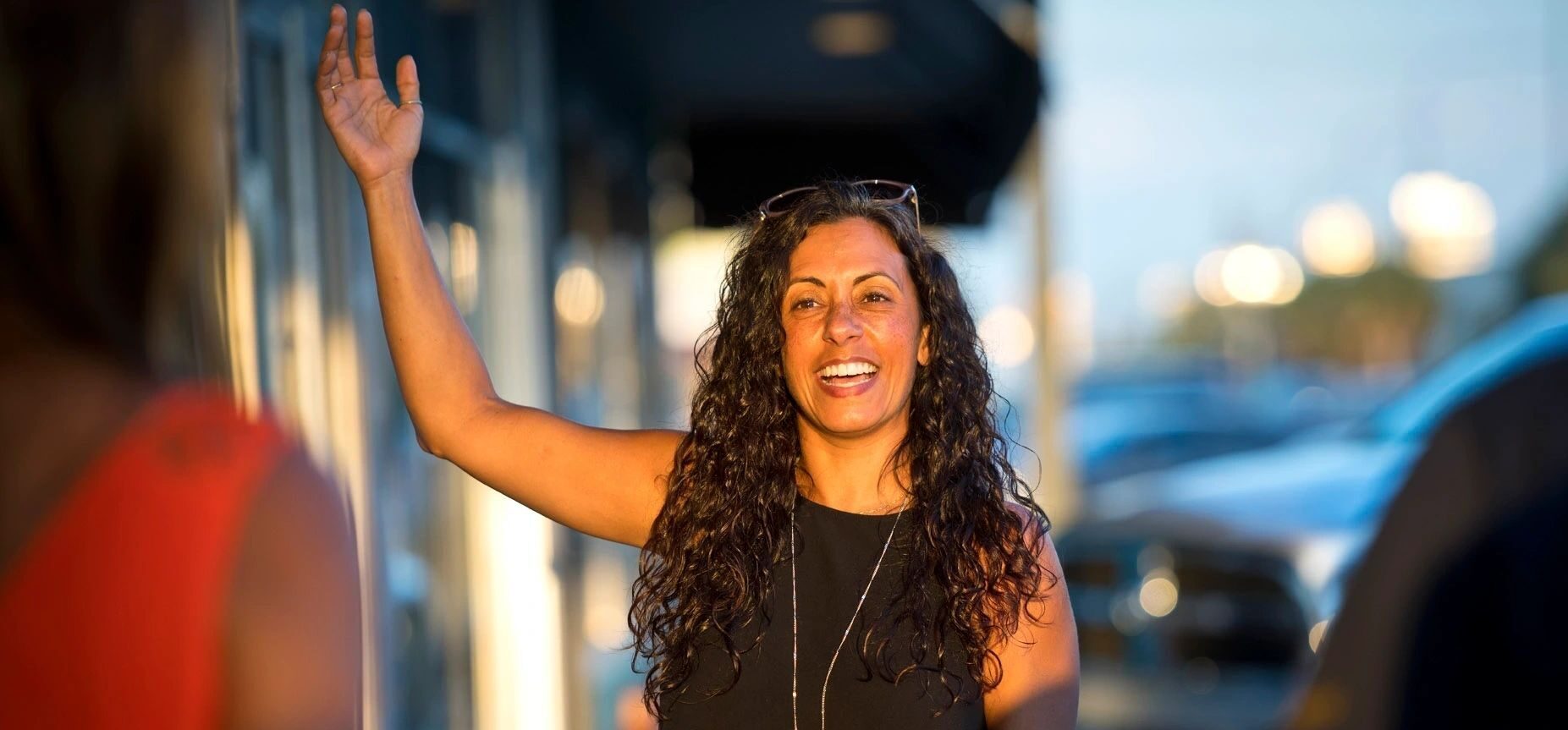 a woman welcoming people in front of a building