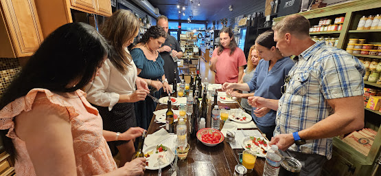 a group of people preparing food with olive oil and vinegar